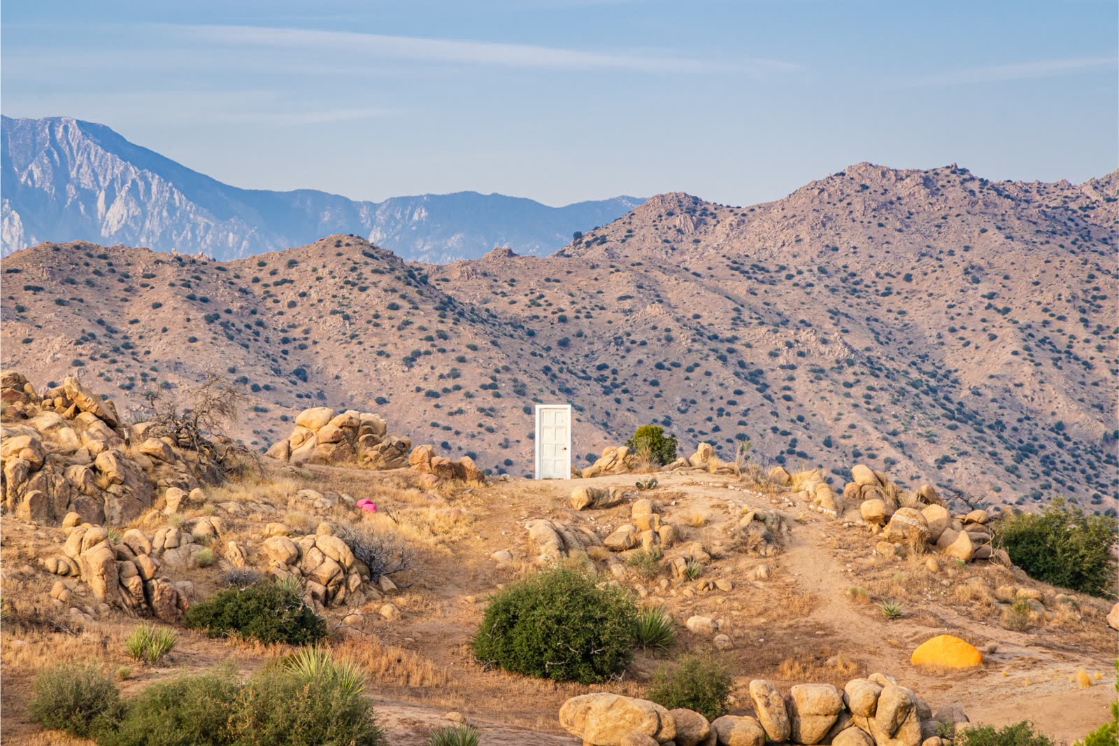 The high desert at ESCAPE — 140 acres of unobstructed Joshua Tree landscape, golden hour light, mountain views to Palm Springs