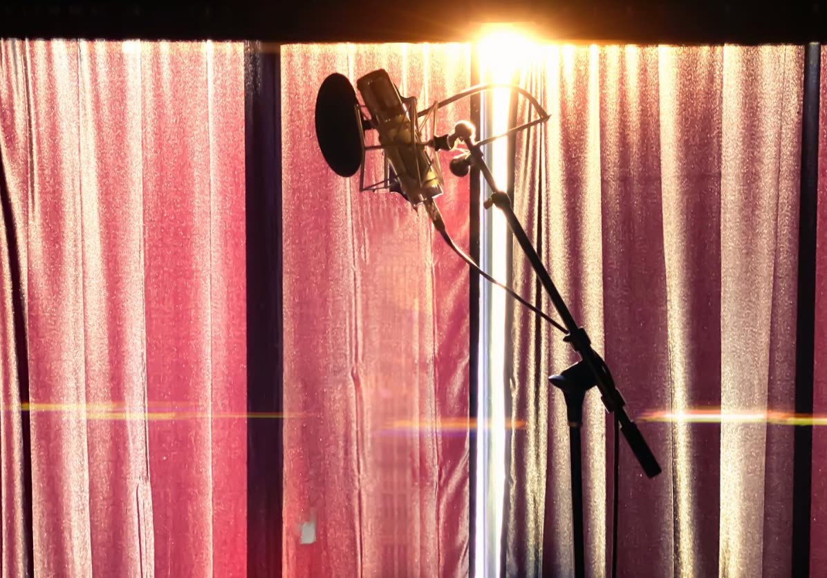 A microphone against the red curtain at ESCAPE Studios