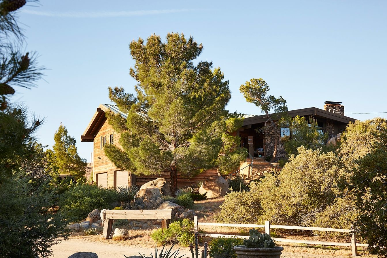 The Main House at ESCAPE — the original wood-and-stone ranch house at the heart of the compound