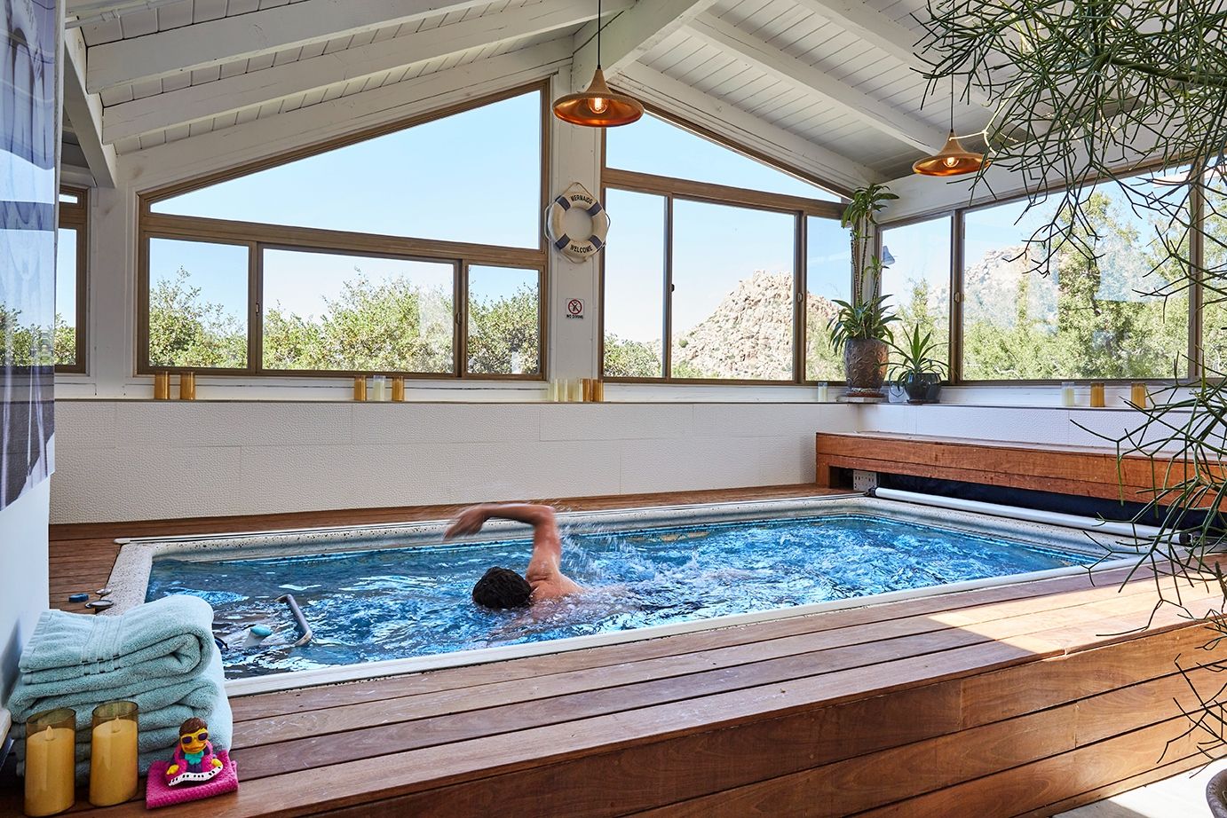 The endless pool in the spa at ESCAPE, under a vaulted ceiling with a desert mountain view